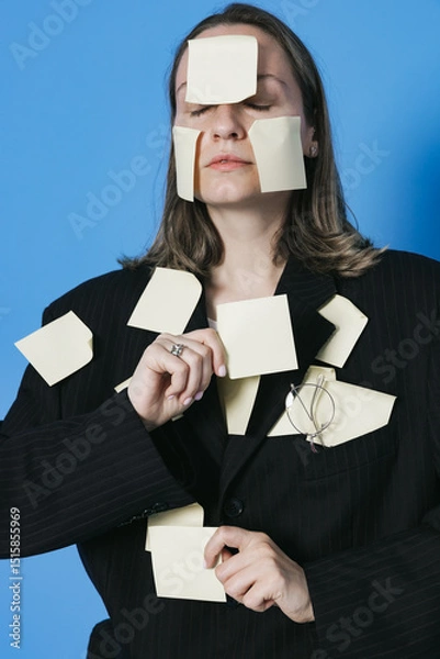 Fototapeta A lot of work and multitasking concept. Business woman is tired. She has got a lot of yellow stickers notes on her suit and face.