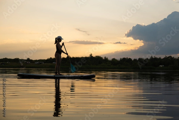 Obraz Paddleboarding at Sunset on a Tranquil Lake