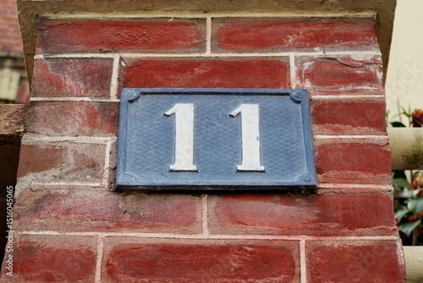 Obraz Numéro 11. Plaque de numéro de rue sur façade de brique rouge.