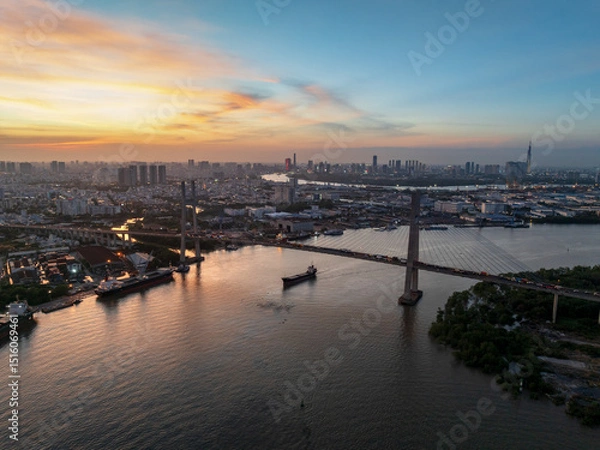Fototapeta Dusk view of Phu My bridge over water with Ho Chi Minh city skyline in the background at twilight