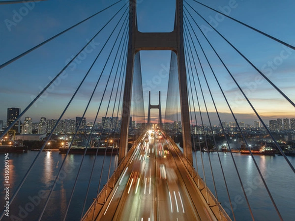 Fototapeta Phu My bridge glows under twilight in Ho Chi Minh City, showcasing the vibrant urban skyline