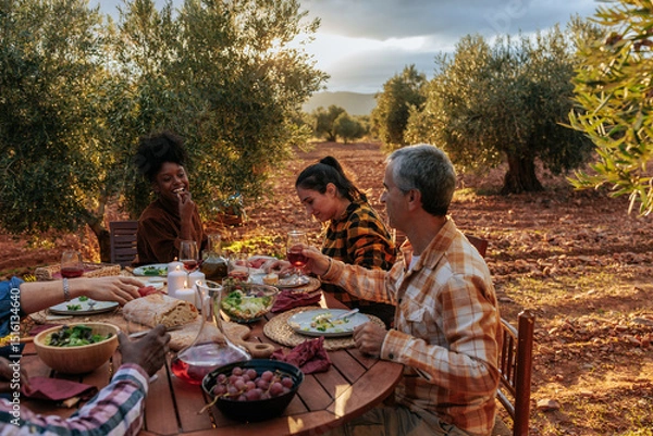 Fototapeta Farmers enjoying dinner together at olive grove after harvesting olives