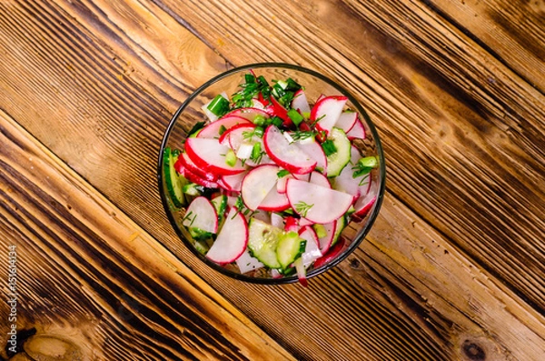 Fototapeta Vegetarian salad with radish and cucumbers. Top view