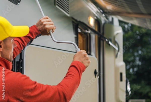 Fototapeta Man Adjusting the Awning of an RV in a Cozy Outdoor Campsite During the Afternoon
