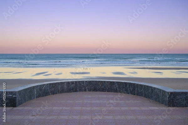 Fototapeta Majestic view of Sidi Ifni beach at sunset with soft waves and colorful sky