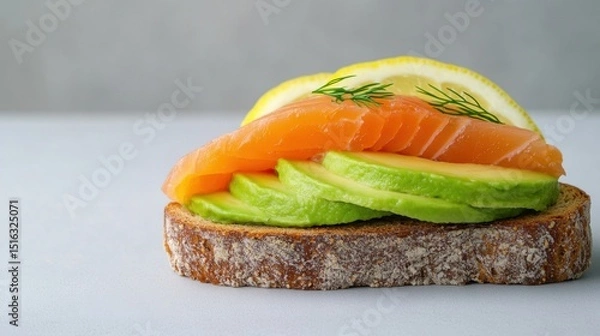 Fototapeta Tasty toast with avocado, salmon and lemon on gray background