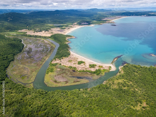 Fototapeta Aerial view of the Ropotamo river mouth in Bulgaria, where the river flows into the Black Sea. Pristine turquoise water, sandbanks, wetlands, and dense forest meet in a stunning natural landscape
