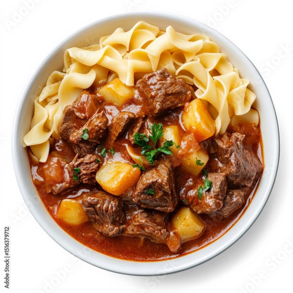 Fototapeta A bowl of beef goulash with fork-tender meat, potatoes, and a paprika-rich sauce, served with buttered noodles on the side.