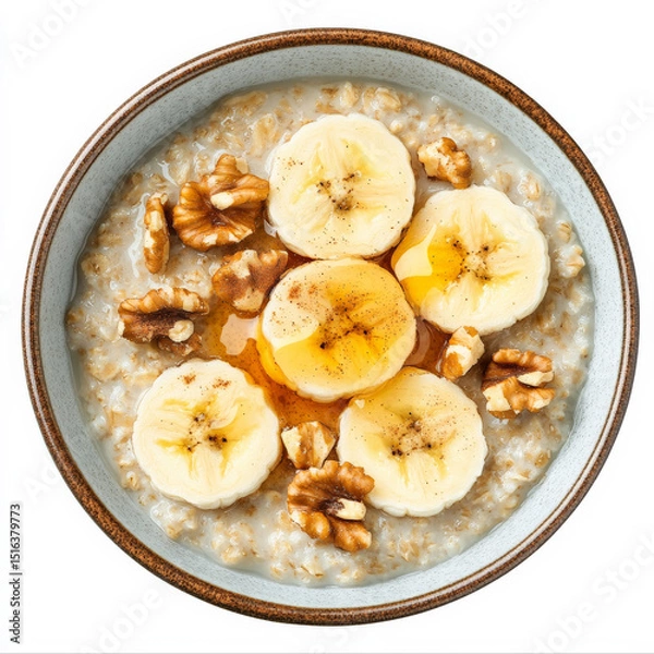 Fototapeta A breakfast bowl of warm oatmeal topped with banana slices, chopped walnuts, cinnamon, and a drizzle of honey.