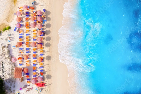 Fototapeta Summer vacation and rest. Beach, people and umbrellas. Top view from drone at the beach and azure sea. View on the coast from drone. Background, wallpaper, postcards.