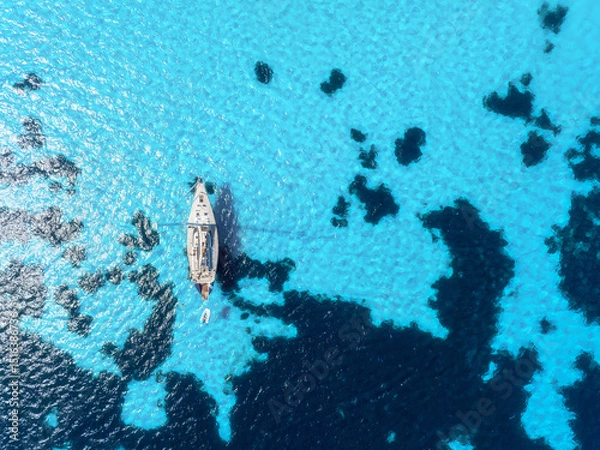 Fototapeta Summertime vacation. Drone view on the yacht. Sail yacht on the sea as a background. .Sea and waves from top view. Blue water background from top view. Top view from drone.