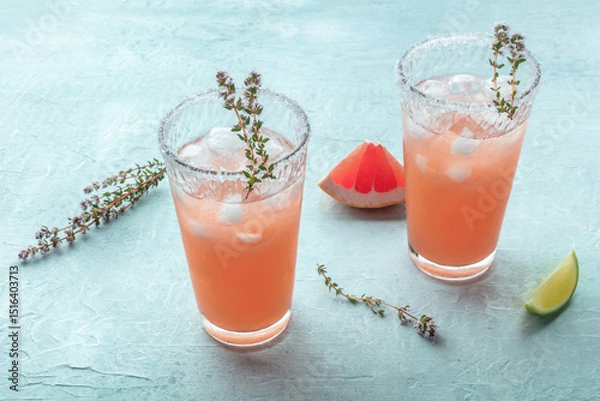 Fototapeta Salty Dog cocktail with fresh grapefruit juice, lime juice, and thyme, on a slate background