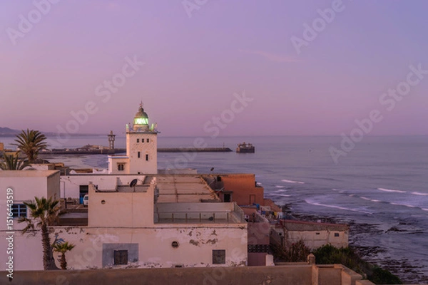 Fototapeta Sidi Ifni light tower illuminating the Moroccan coastline at dusk