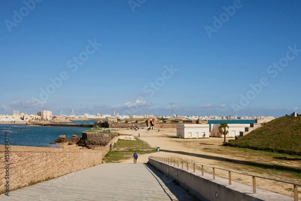 Fototapeta San Sebastián Castle and coastal promenade view in Cádiz on a sunny day