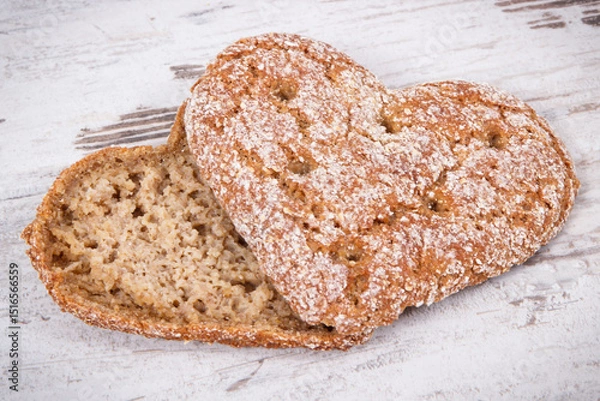 Obraz Fresh homemade wholegrain bread in shape of heart for breakfast. Old rustic background