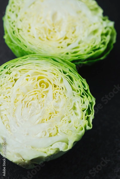 Obraz Two cut cabbage halves on dark background close detail