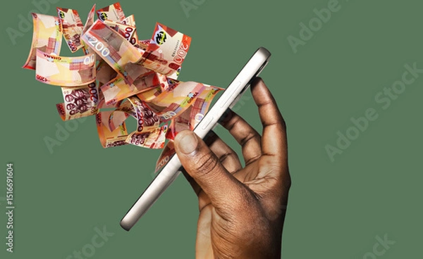 Obraz Hand holding mobile phone with many Ghanaian cedi coming spitting flying out of the screen on green background. side view of phone