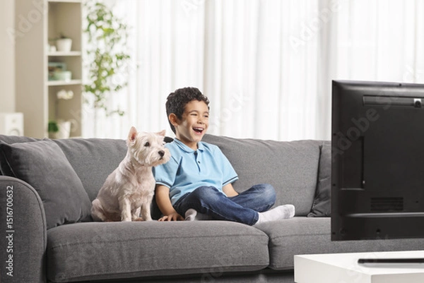Obraz Kid and dog sitting on a sofa at home watching tv