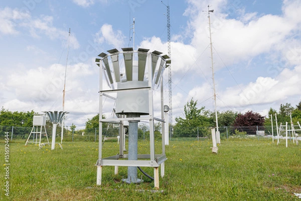 Fototapeta Meteorological station with rain gauge collectors and weather sensors installed on a grassy field