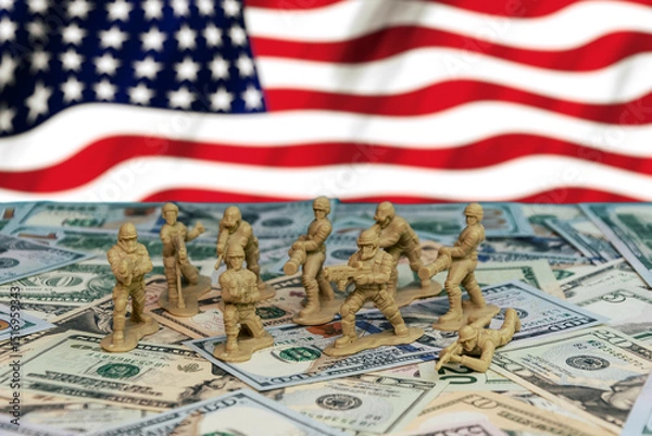 Obraz Militarism and the US economy. Toy soldiers stand on US dollars against the background of the US flag, symbolising the influence of military spending and the economy on world politics.