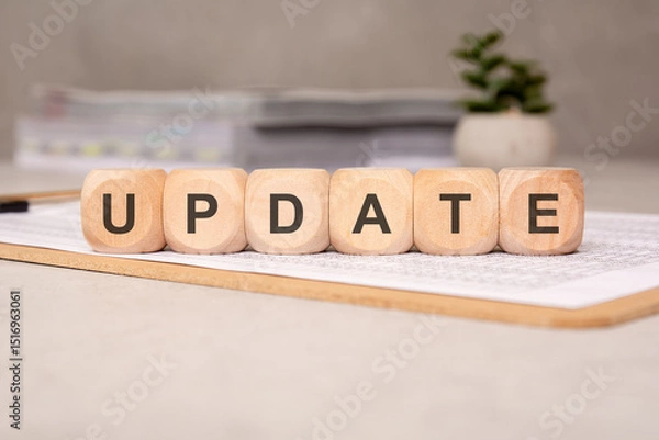 Obraz Wooden cubes spelling UPDATE on clipboard with financial sheets, office background