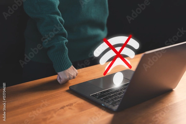 Obraz User using a laptop to connect to wifi with a crossed-out Wi-Fi symbol, representing internet disconnection and network failure stress. Concept of frustrated user waiting for connect to wifi.
