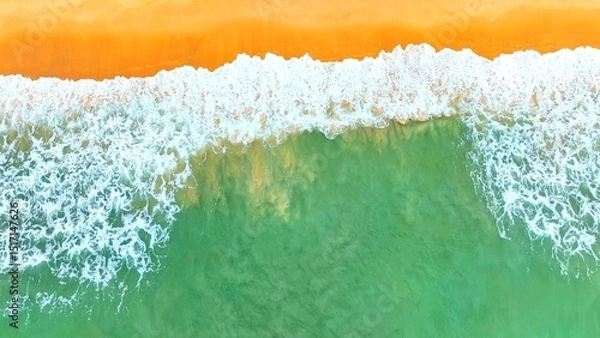 Obraz An aerial view of the ocean's turquoise water meeting a sandy shore, with waves gently crashing, evoking a calm, tropical beach vibe perfect for nature and travel content. Phuket, Thailand.
