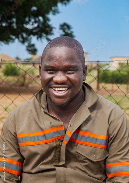 Fototapeta village rural ,portrait of african smiling man, in front of a house with thatched roof , countryside living,