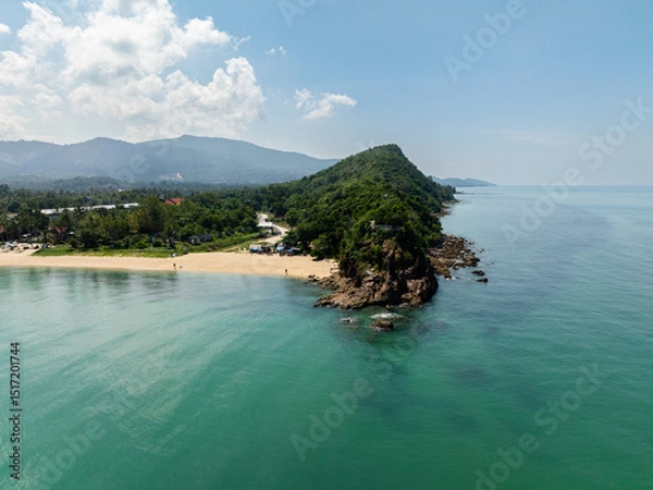 Fototapeta Serene white sand beach surrounded by lush greenery and clear turquoise waters under a sunny sky. Koh Samui, Thailand.