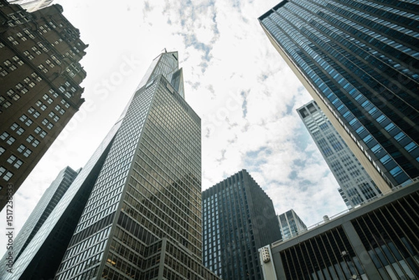 Obraz Classic brownstone and reflective glass buildings rise side by side in Manhattan. This business hub blends historic charm with modern structure.