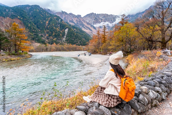 Fototapeta Young couple tourist relaxing and enjoying with beautiful nature autumn foliage at kamikochi in Japan