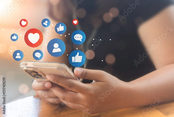 Obraz Woman hand hold smartphone and use social media network application to check new feedback or interactive with people and send emoticon for  react feeling and moment.