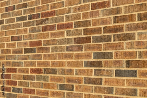 Fototapeta Abstract texture background of an exterior multi-shade reddish brown vintage brick wall surface speckled with blue, in traditional running bond brickwork pattern