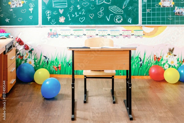 Fototapeta Colorful elementary classroom with decorated desk and chalkboard