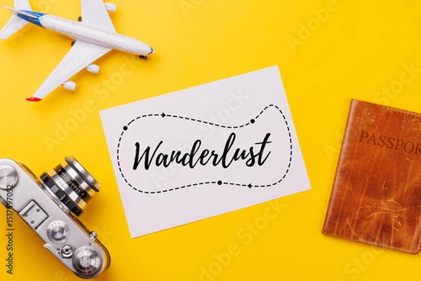 Fototapeta Travel-themed flat lay with blank photo card, camera, toy airplane, and passport