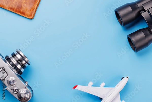 Fototapeta Travel-themed flat lay with toy airplane, camera, and passport