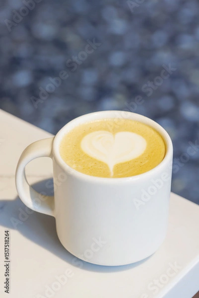 Fototapeta Warm cappuccino in a cup with heart-shaped latte art on top