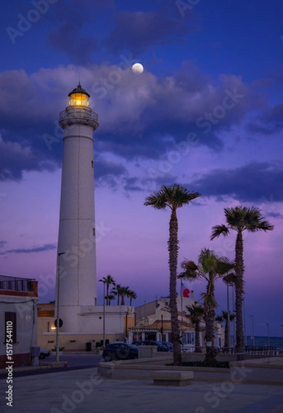 Fototapeta Captivating Twilight at Punta Secca Lighthouse Under a Glowing Moon, Sicily, Italy