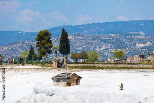 Obraz Pamukkale’s white travertine terraces and ancient city of Hierapolis in Turkey. Rolling hills and blue sky highlighting unique landscape of this site 