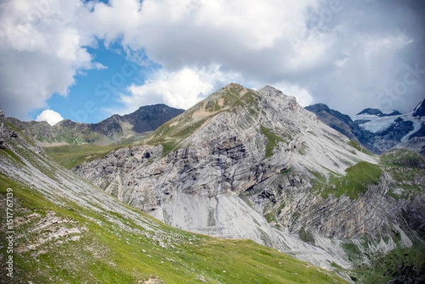Fototapeta Panoramic alpine view with mountain peaks and lush valley