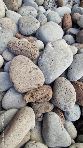 Fototapeta Madeira’s beaches are often covered in smooth pebbles made from igneous rocks like basalt and trachyte, shaped by erosion and wave action. These volcanic stones vary in color and texture, reflecting t