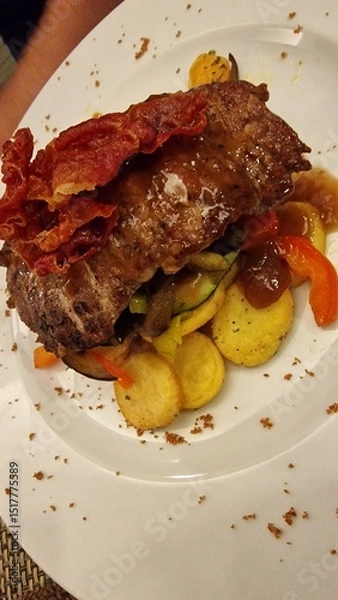 Fototapeta A juicy steak of meat is served alongside golden, crispy potatoes, creating a classic and hearty meal. The rich flavors and satisfying textures make it a favorite comfort dish in many cuisines.