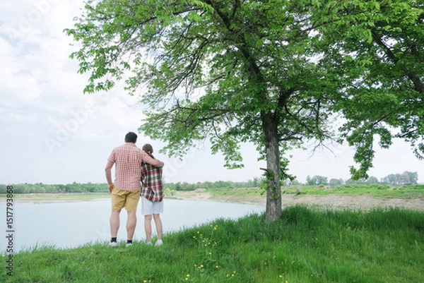 Fototapeta Family on picnic near the lake, looking at view