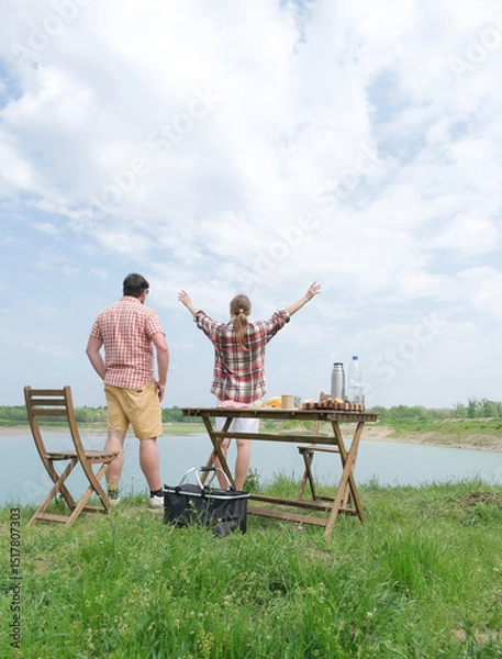 Fototapeta Family on picnic near the lake, looking at view