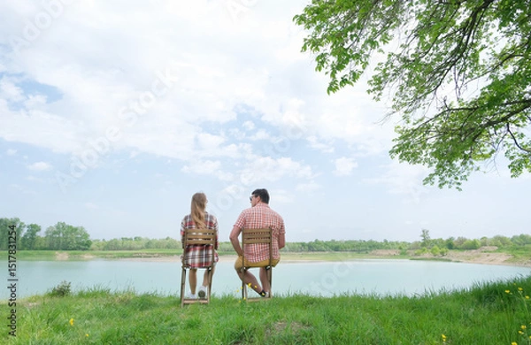 Fototapeta Family on picnic near the lake, looking at view