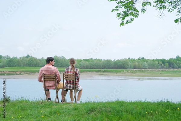 Fototapeta Family on picnic near the lake, looking at view