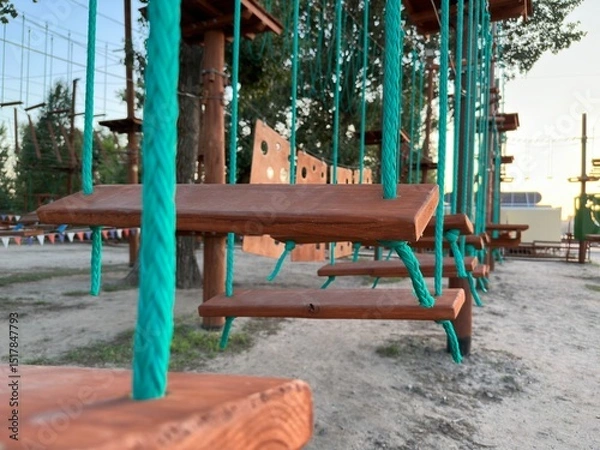 Fototapeta Rope park. Construction of rope parks on trees. A rope park, or a tie park, is an amusement park on which various elements are installed, such as bridges, cable crossings, stairs and bungee jumps