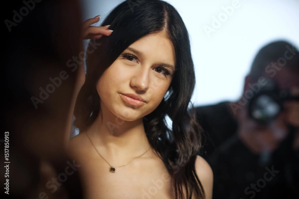 Obraz A young brunette woman poses elegantly for a modern fashion campaign. She is photographed by a professional in a well lit studio for use on social media