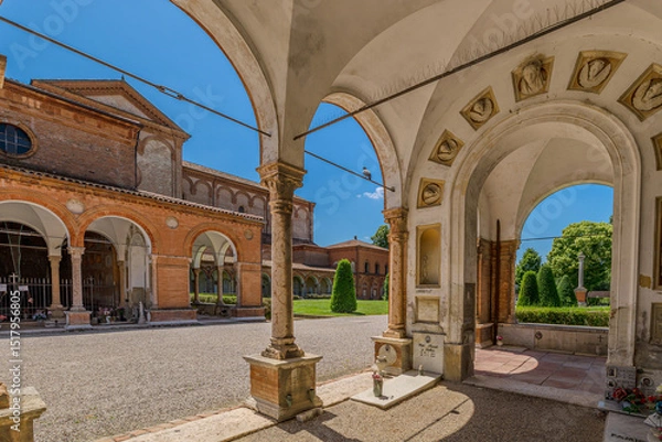 Fototapeta Ferrara, Italy - May 17, 2025: Wide angle view of the entrance to the Ferrara Charterhouse, showing the terracotta arch, decorations, and the hallway with arches and domes, in Ferrara, Italy