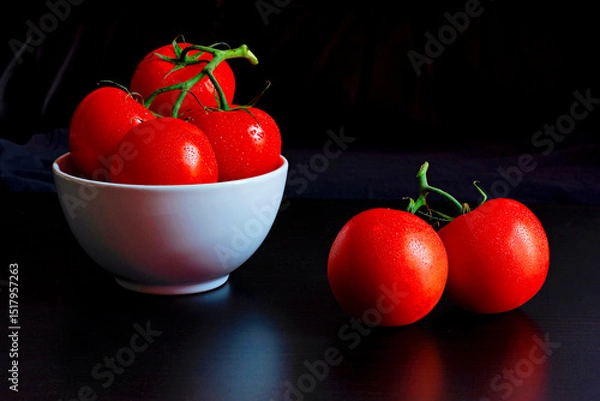 Obraz Solanum lycopersicum, commonly known as tomatoes closeup against a black backdrop